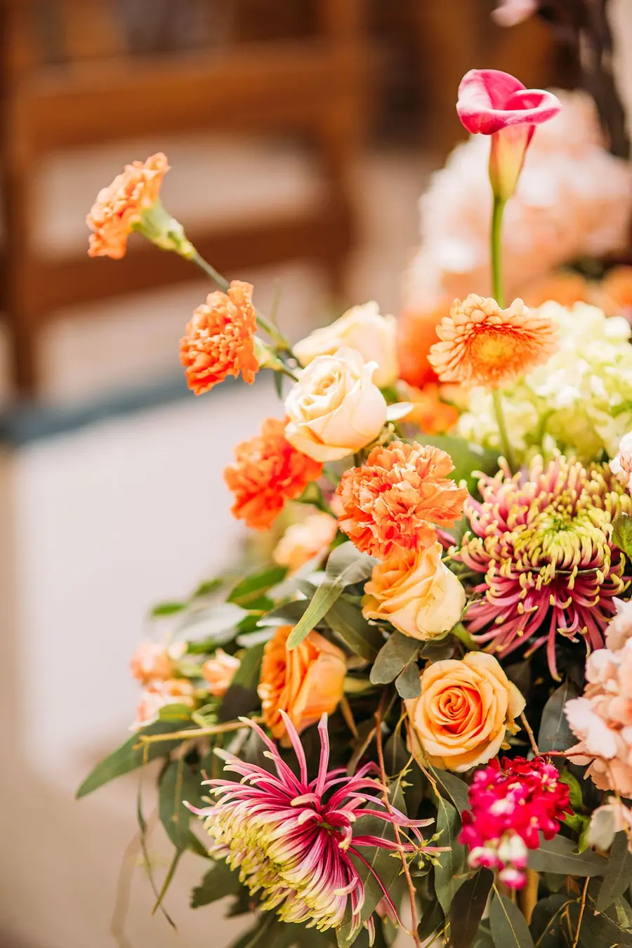Saisongesteck mit orangefarbenen Rosen und Dahlien