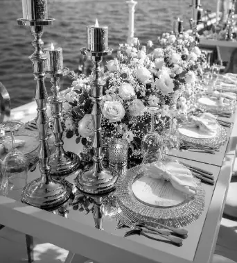 Table de dîner sur un yacht avec chandeliers et fleurs blanches