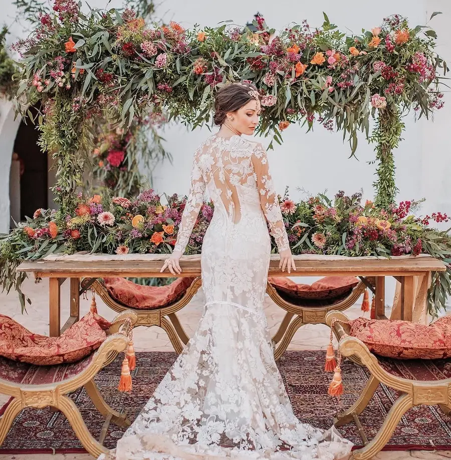 Bride in front of a flower-filled top table at a Mallorca wedding